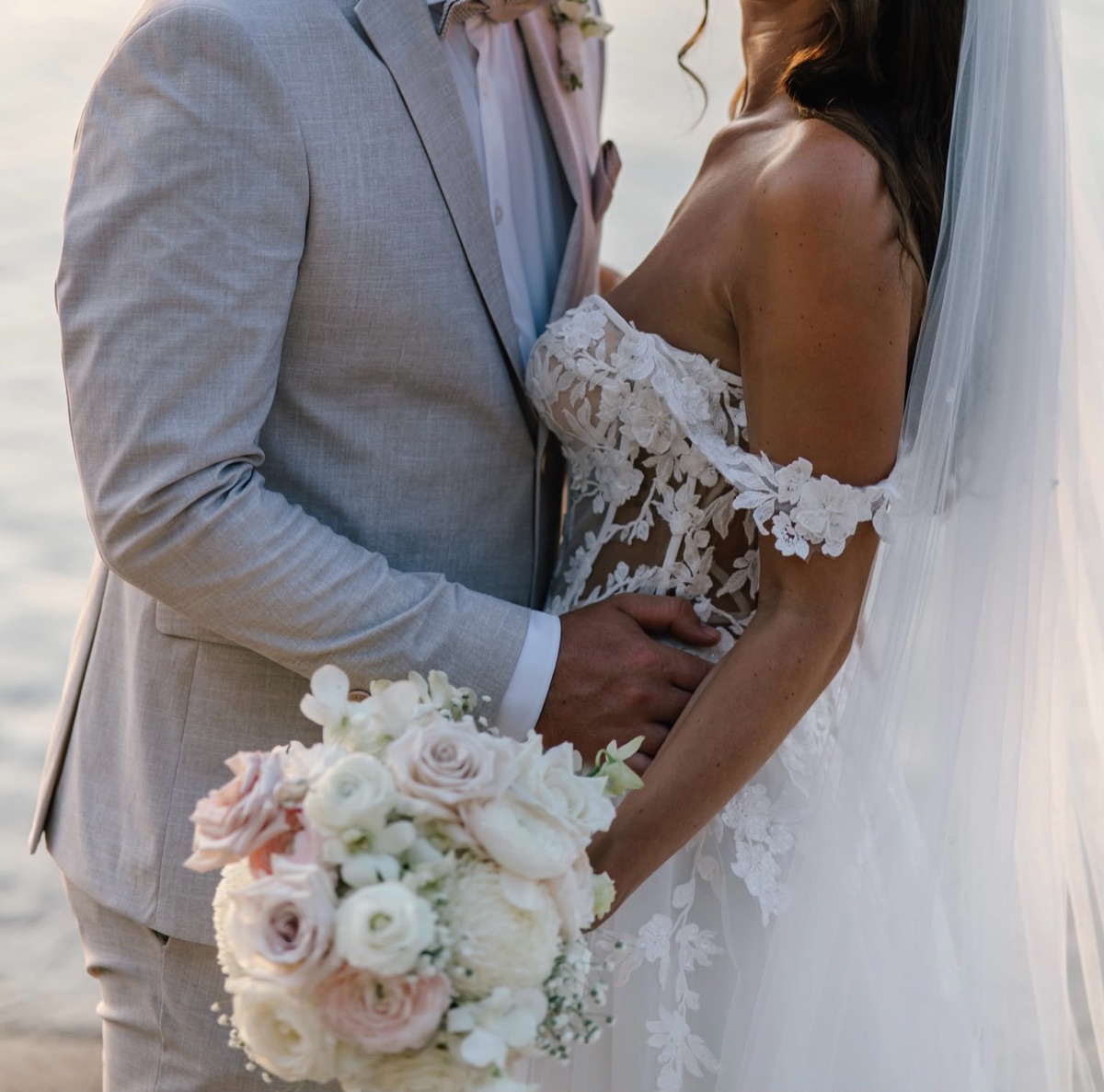 Brautpaar mit zartem Brautstrauß in Weiß und Blush aus Rosen und Ranunkeln